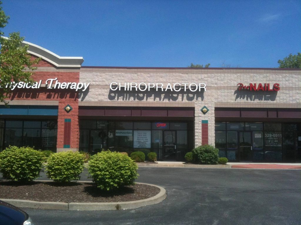 Storefront of Wolfrum Crossing Chiropractic in the Wolfrum Crossing shopping center, with the CHIROPRACTOR sign above the entrance and the parking lot in front